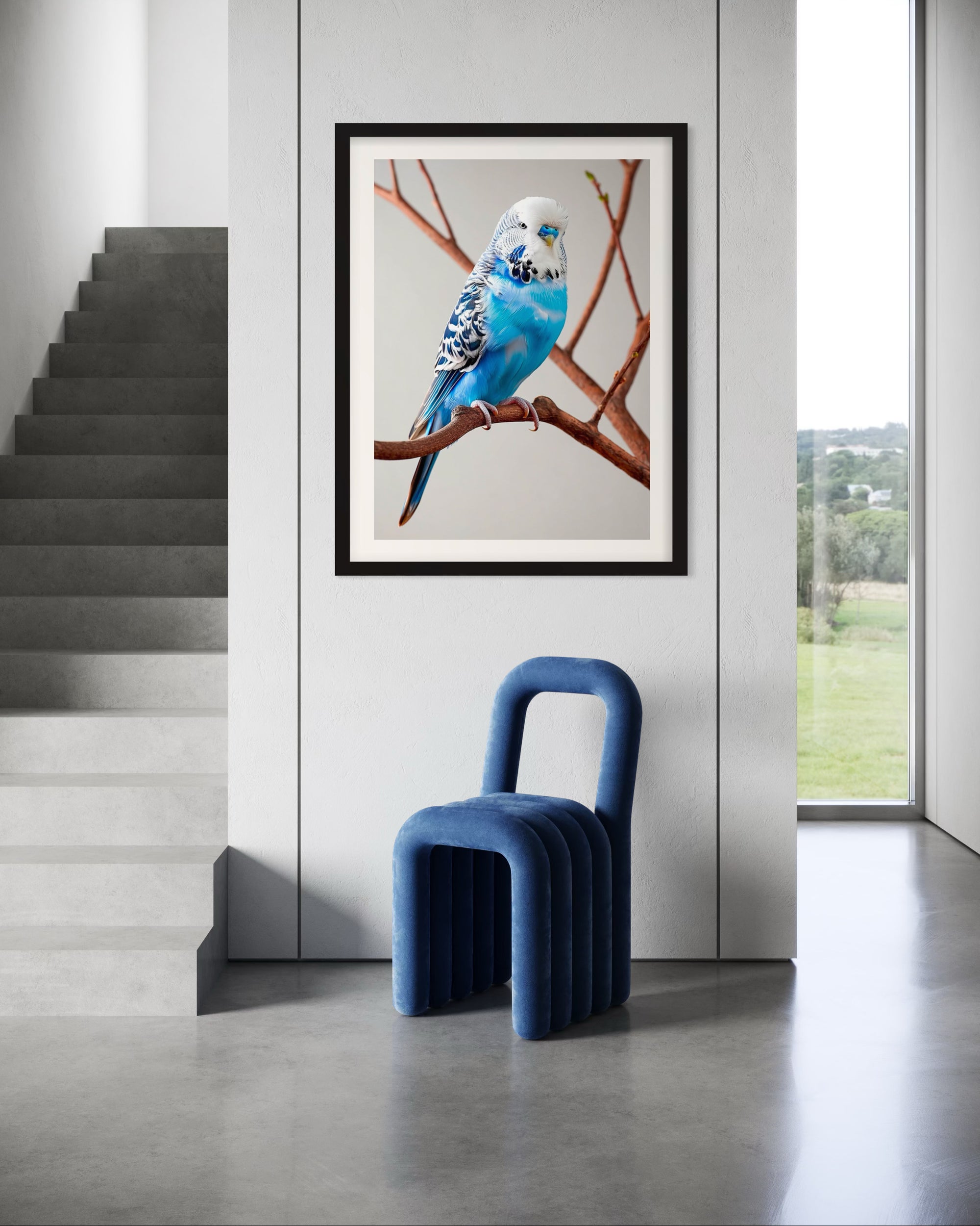 Framed artwork of a blue budgerigar on a branch in a modern interior setting with a blue chair.