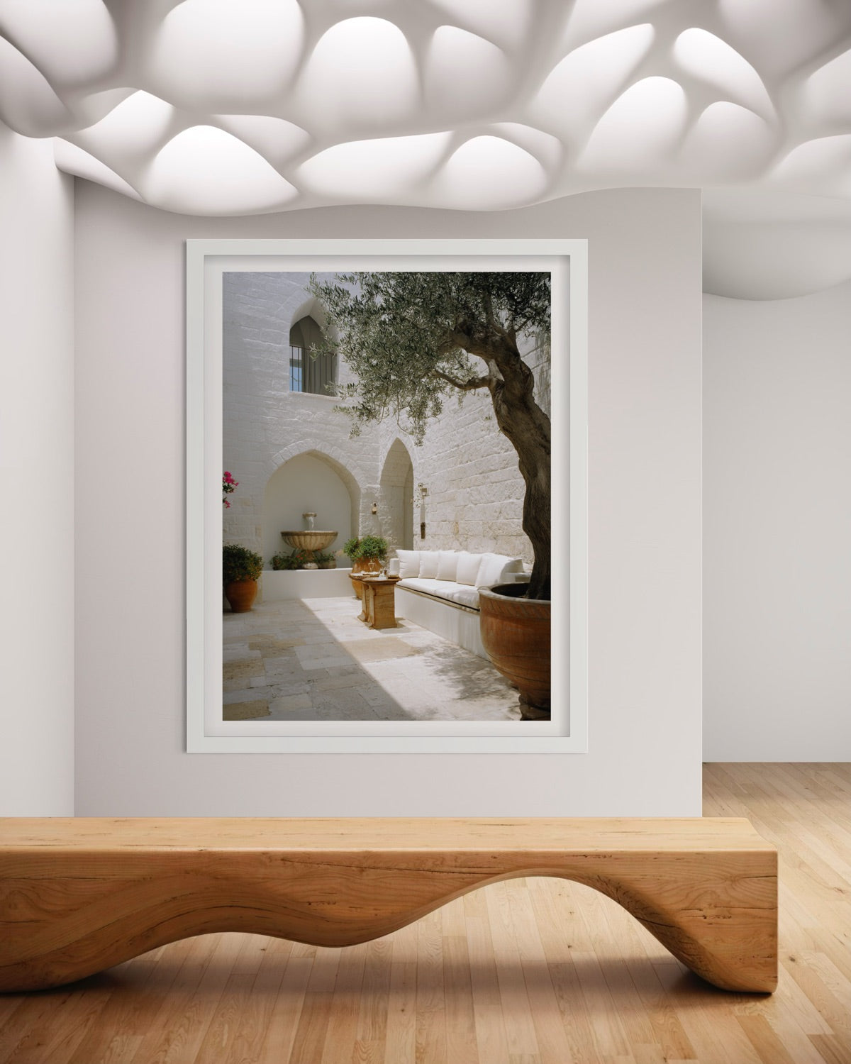 Olive Courtyard Mediterranean wall art featuring a sunlit white stone courtyard, mature olive tree, arched architecture and neutral outdoor seating.